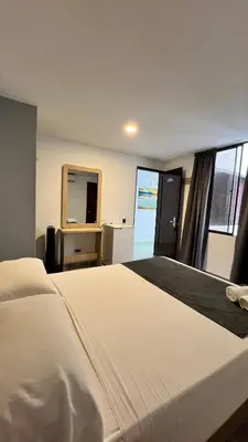 a large white bed in a room with a window at Hotel Gran Conquistador 33 in Medellín