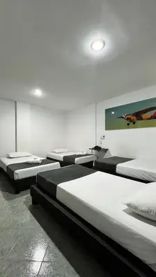 a room with four beds and a painting on the wall at Hotel Gran Conquistador 33 in Medellín