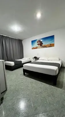 a room with two beds and a painting on the wall at Hotel Gran Conquistador 33 in Medellín
