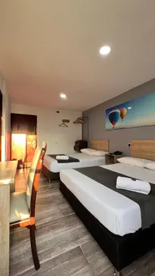 a hotel room with two beds and a couch at Hotel Gran Conquistador 33 in Medellín
