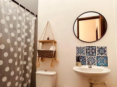 a bathroom with a mirror and a toilet and a sink at Aloja-T en Apartamento amoblado 6 con balcón Ciudad Bolivar in Ciudad Bolívar