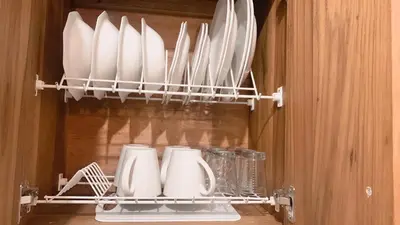 a cupboard with white plates and utensils in it at Aloja-T en Apartamento amoblado 6 con balcón Ciudad Bolivar in Ciudad Bolívar