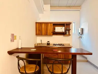 a kitchen with a wooden table and two chairs at Aloja-T en Apartamento amoblado 6 con balcón Ciudad Bolivar in Ciudad Bolívar