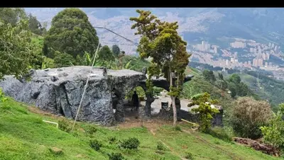 an old building on a hill with a city in the background at Glamping Spa & Coffee Tour in Medellín