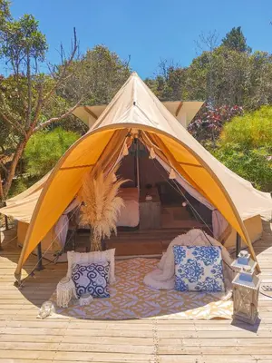 a tent with a bed and pillows on a deck at AKOA GLAMPING Eco-Luxury Hotel in Guarne