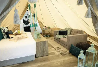 a room with a tent with two beds and a couch at AKOA GLAMPING Eco-Luxury Hotel in Guarne