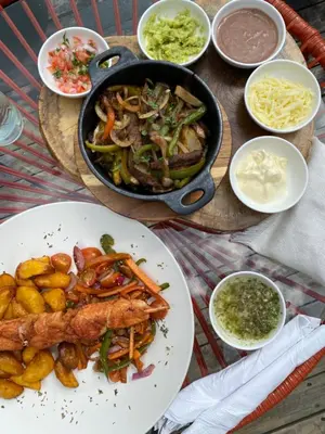 a table with a pan of food and a plate of food at AKOA GLAMPING Eco-Luxury Hotel in Guarne