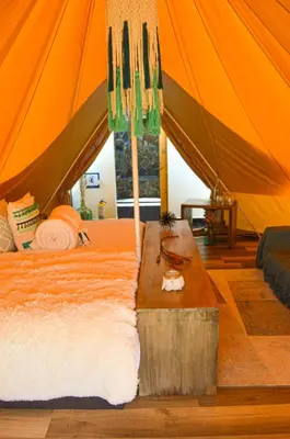 a bedroom with a bed and a table in a tent at AKOA GLAMPING Eco-Luxury Hotel in Guarne