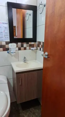 a bathroom with a sink and a toilet and a mirror at HOSTERÍA BRISAS DEL RÍO in Marinilla