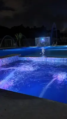 a swimming pool at night with blue lights at HOSTERÍA BRISAS DEL RÍO in Marinilla
