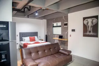 a bedroom with a bed and a couch in a room at Edificio Helena in Medellín