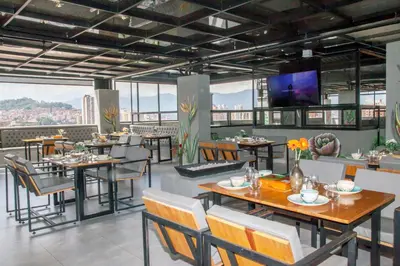 a restaurant with tables and chairs and a flat screen tv at Edificio Helena in Medellín