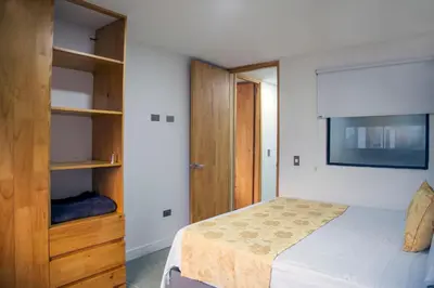a bedroom with a bed and a tv on the wall at Edificio Helena in Medellín