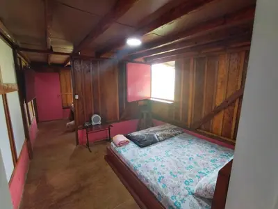 a bedroom with a bed in a room with wooden walls at Finca Cafetera el Coral in Jardin