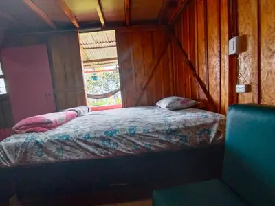 a bedroom with a bed in a room with a window at Finca Cafetera el Coral in Jardin