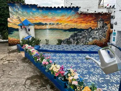 a wall with a painting of a windmill and flowers at Cabaña Santorini Colombiano in Puerto Triunfo
