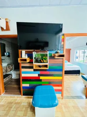 a bedroom with a bunk bed with a colorful dresser at Cabaña Santorini Colombiano in Puerto Triunfo
