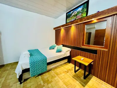 a small bedroom with a bed and a tv at Cabaña Santorini Colombiano in Puerto Triunfo