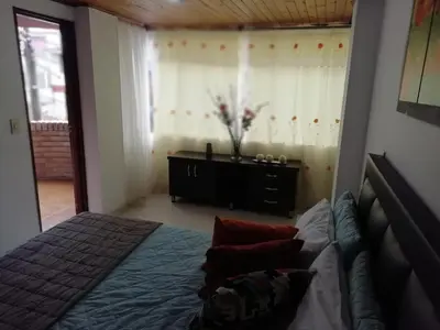 a bedroom with a bed and a dresser at Habitaciones en Edificio Ginebra Manizales in La Linda