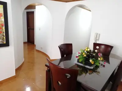 a dining room with a table with flowers on it at Habitaciones en Edificio Ginebra Manizales in La Linda
