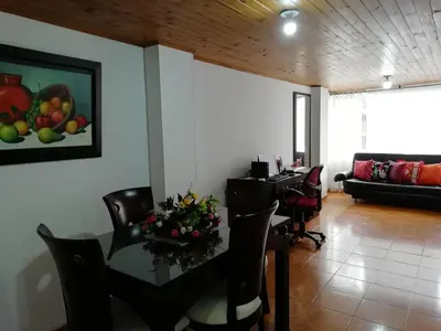 a dining room with a table and chairs and a couch at Habitaciones en Edificio Ginebra Manizales in La Linda