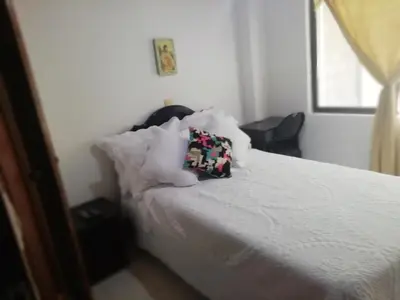 a bedroom with a bed with a pillow on it at Habitaciones en Edificio Ginebra Manizales in La Linda