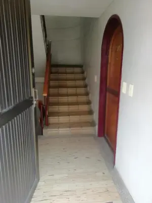 a hallway with a staircase with a door and a stair case at Habitaciones en Edificio Ginebra Manizales in La Linda