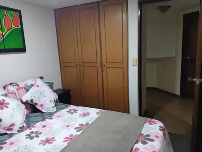 a bedroom with a bed with pink and white pillows at Habitaciones en Edificio Ginebra Manizales in La Linda