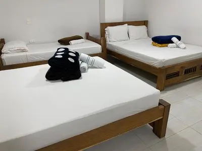 a room with three beds and a bag sitting on them at HOTEL LA SELVA JARDIN in Jardin