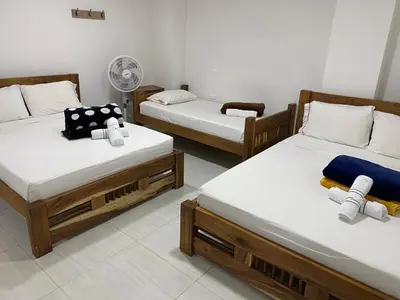 a room with three beds and a fan at HOTEL LA SELVA JARDIN in Jardin