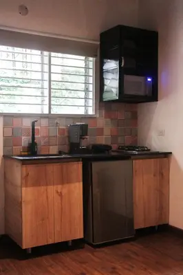 a kitchen with a sink and a stove and a microwave at Studio in Poblado near Envigado FRN103 By Roots Rentals in Medellín