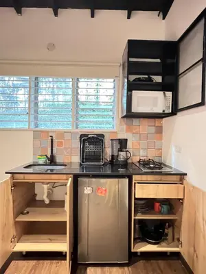 a kitchen with a sink and a refrigerator at Studio in Poblado near Envigado FRN103 By Roots Rentals in Medellín