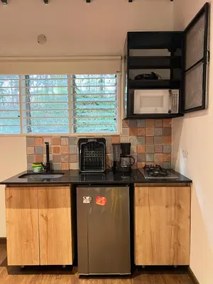 a kitchen with a sink and a stove and a refrigerator at Studio in Poblado near Envigado FRN103 By Roots Rentals in Medellín