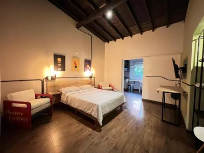a bedroom with a bed and a chair and a desk at Loft equipado en Poblado cerca de Envigado FRN107 By Roots Rentals in Medellín