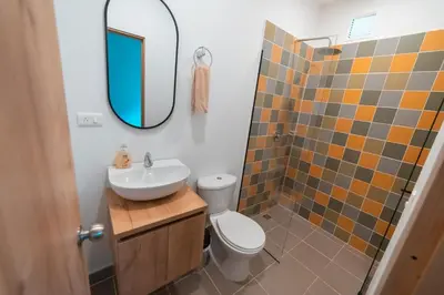a bathroom with a sink and a toilet and a mirror at Loft equipado en Poblado cerca de Envigado FRN107 By Roots Rentals in Medellín