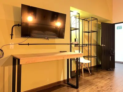 a room with a desk with a television on the wall at Loft equipado en Poblado cerca de Envigado FRN107 By Roots Rentals in Medellín