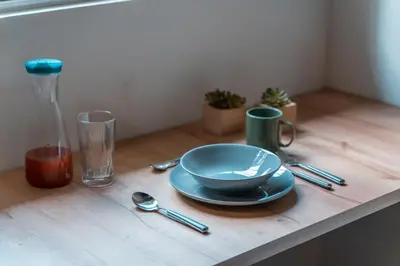 a table with a blue bowl and spoon and a glass at Loft equipado en Poblado cerca de Envigado FRN107 By Roots Rentals in Medellín