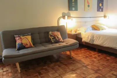 a living room with a couch and a bed at Apartaestudio amueblado en Poblado FRN106 By Roots Rentals in Medellín