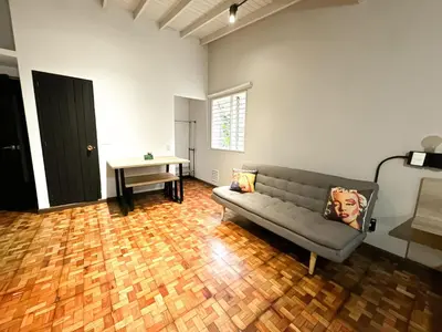 a living room with a couch and a table at Apartaestudio amueblado en Poblado FRN106 By Roots Rentals in Medellín