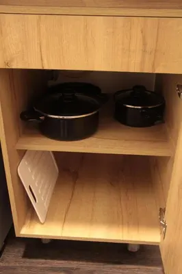two pots and pans in a wooden cabinet at Apartaestudio amueblado en Poblado FRN106 By Roots Rentals in Medellín