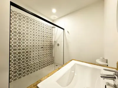 a bathroom with a tub and a glass shower at Apartaestudio amueblado en Poblado FRN106 By Roots Rentals in Medellín