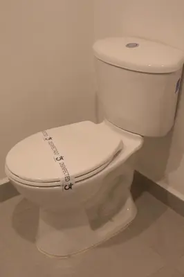 a white toilet with a sticker on the seat at Apartaestudio amueblado en Poblado FRN106 By Roots Rentals in Medellín