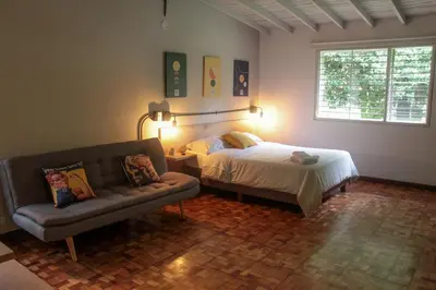 a bedroom with a bed and a couch and a window at Apartaestudio amueblado en Poblado FRN106 By Roots Rentals in Medellín