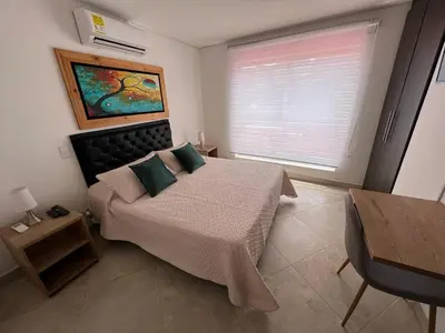 a bedroom with a large bed and a window at Apartamento Amoblado laureles estadio in Medellín