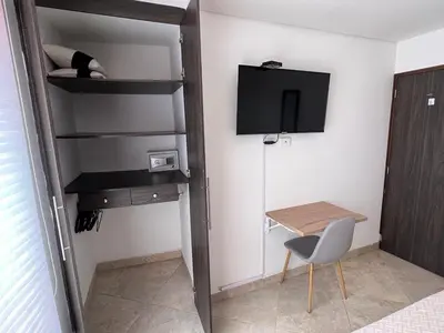 a small room with a desk and a tv and a chair at Apartamento Amoblado laureles estadio in Medellín