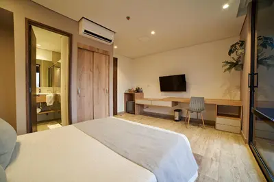a bedroom with a bed and a desk with a television at Eutopiq Hotel in Medellín