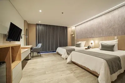 a hotel room with two beds and a television at Eutopiq Hotel in Medellín