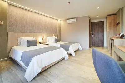 a hotel room with two beds and a couch at Eutopiq Hotel in Medellín