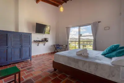 a bedroom with a large bed and a window at La Villa, Espectaculares vistas al lago Peñol-Guatape in Guatapé