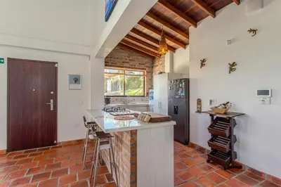 a kitchen with a counter and a refrigerator at La Villa, Espectaculares vistas al lago Peñol-Guatape in Guatapé